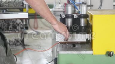 生产PVC窗，男子在切割机上安装PVC型材，并将其切割，以适应进一步的装配。